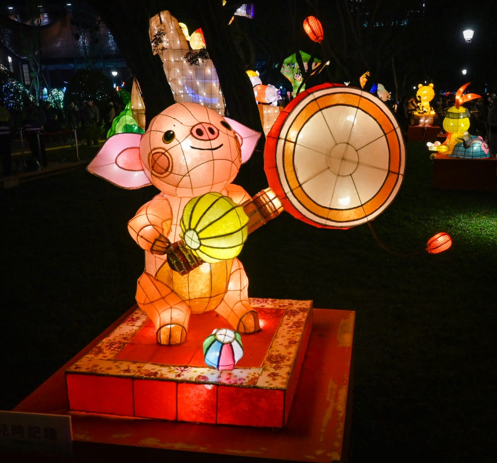 A pink pig representing the Chinese zodiac plays a spinning drum in the central display area of the Taiwan Lantern Festival