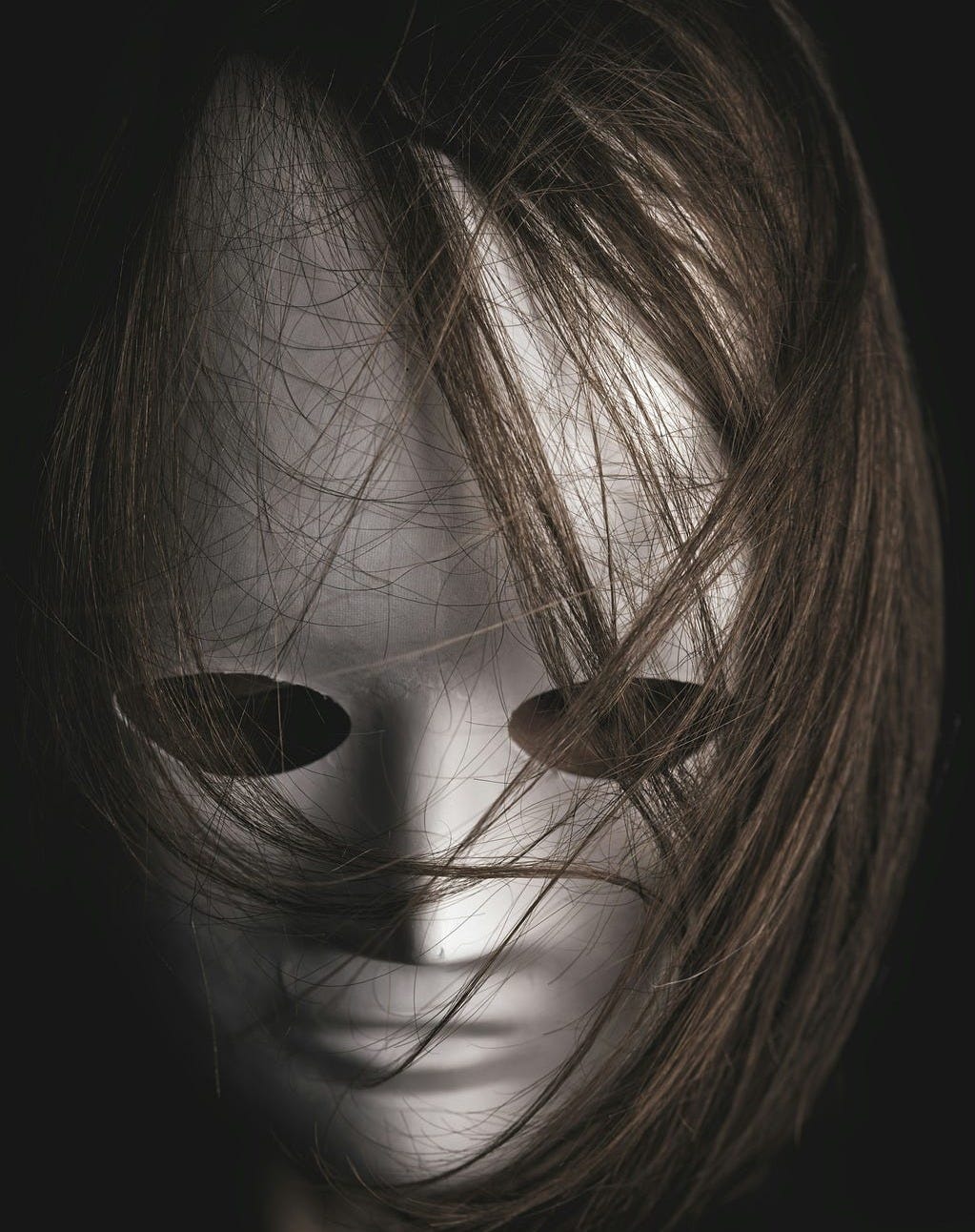 a humanish/robotish white mask with dark real hair a humanish/robotish white mask with dark real hair