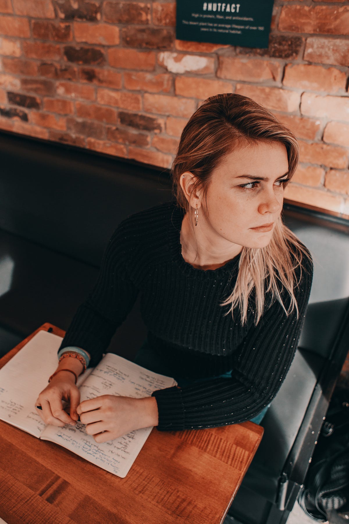 A poet at her writing desk, looking wistfully into the distance