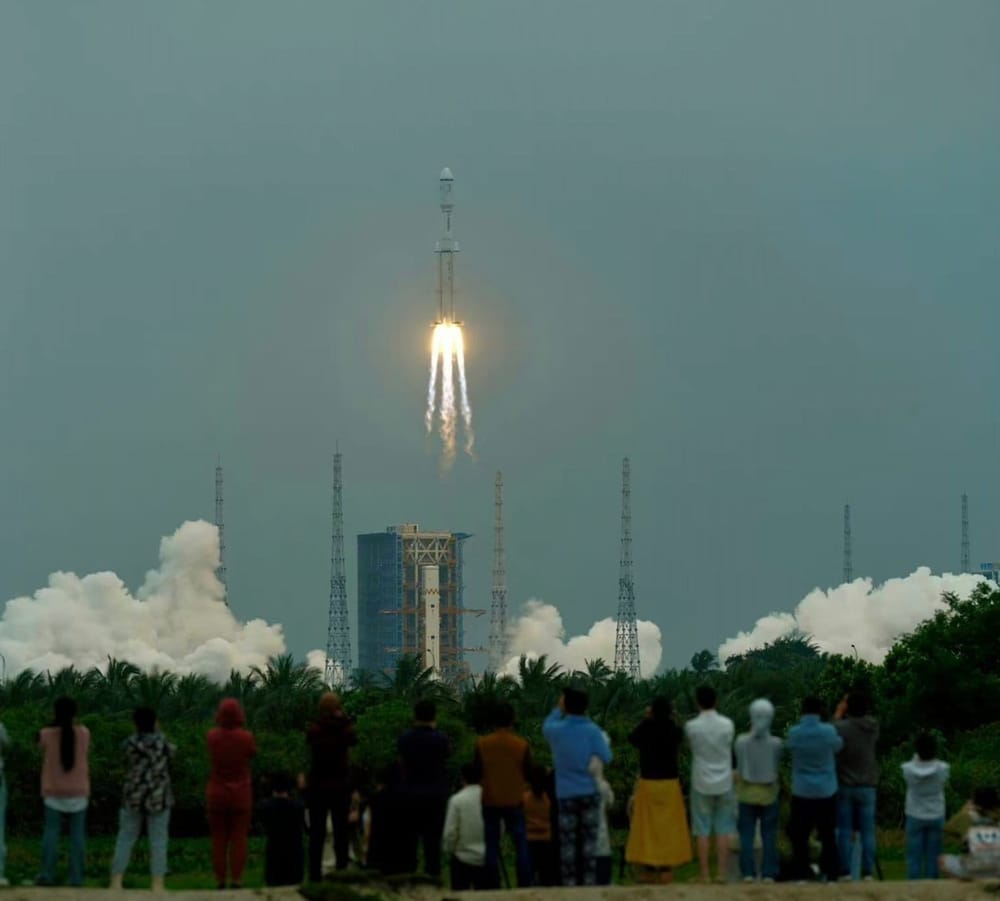 The Long March 8 Y3 lifting off from Launch Complex 2 in the background with a crowd watching in the foreground. ©黑白猫名字被占用 via Wu Lei