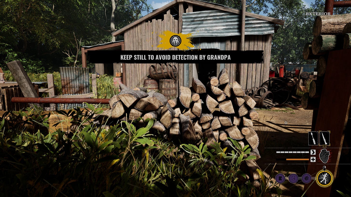 A screenshot of the game The Texas Chainsaw Massacre showing some sheds and woodpiles next to a bush where the player character is hiding. The caption says "KEEP STILL TO AVOID DETECTION BY GRANDPA".