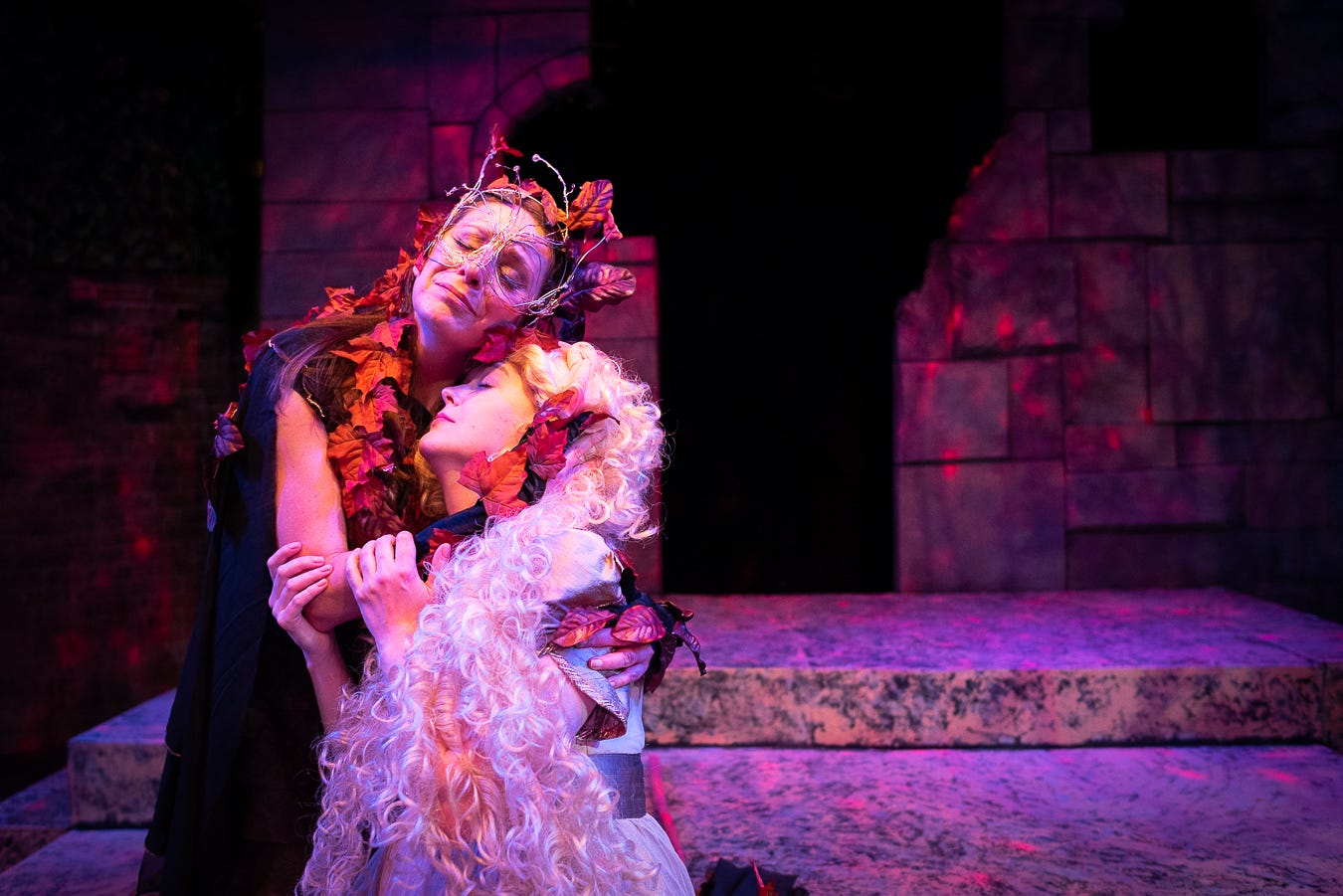Susan Derry in leaf headdress as the witch in Into The Woods holding Holly Kelly Farella as Rapunzel.