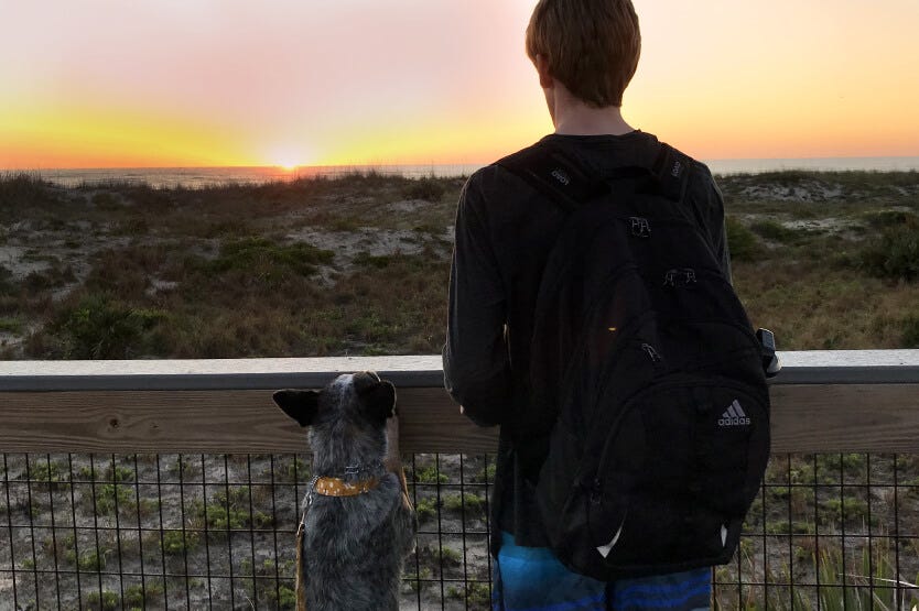 Sean and Scout watching a sunrise together at Smyrna Dunes Park