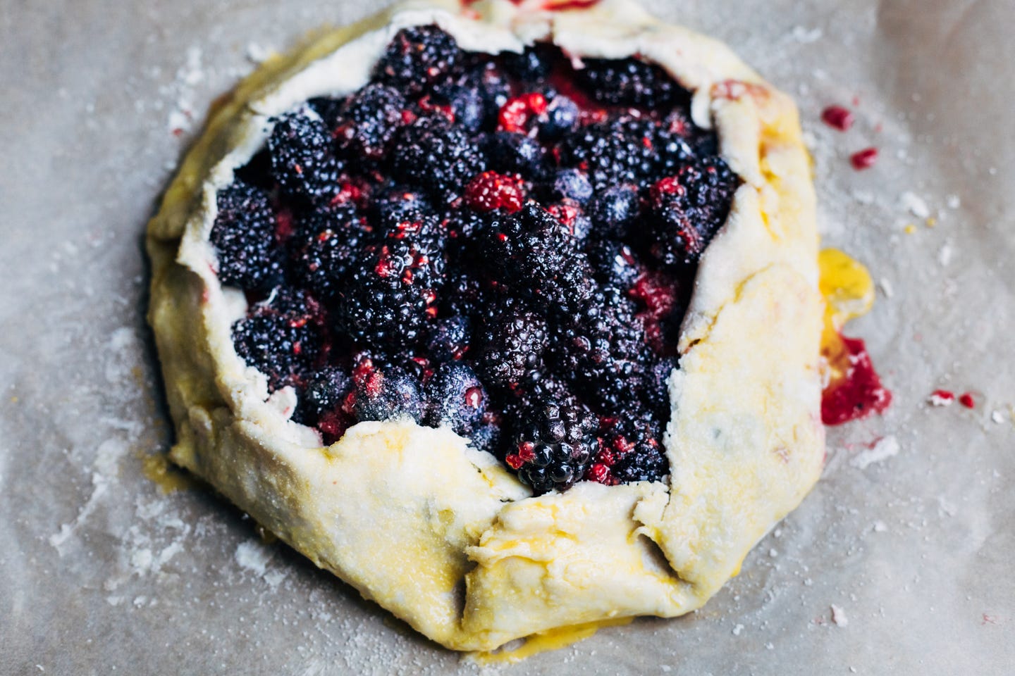 An uncooked berry galette on a baking sheet