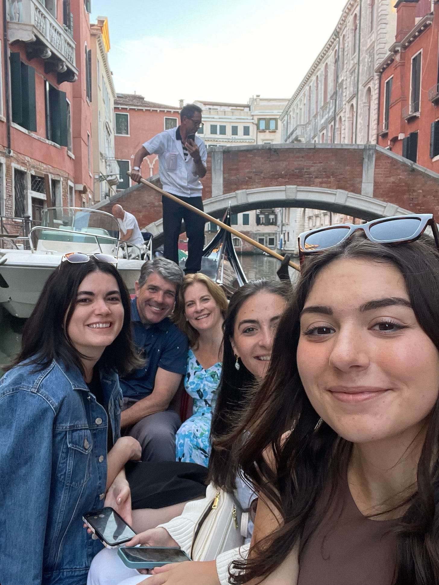 Party of five in a Venetian gondola with a gondolier in the background