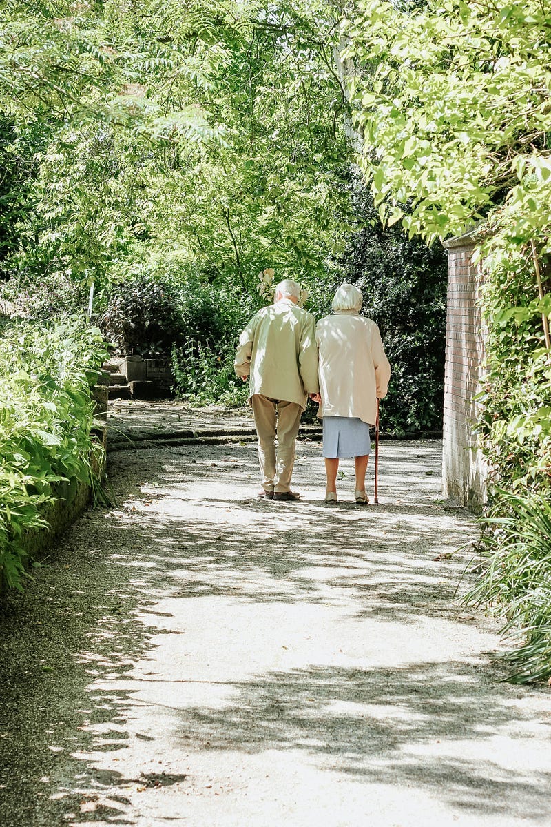 Elderly couple walking together in the park.