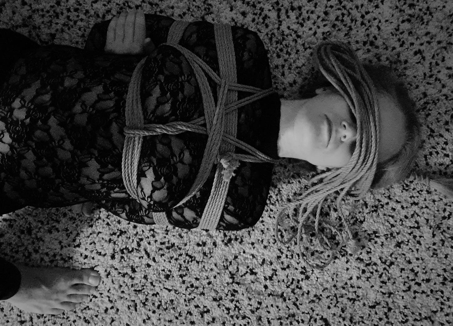 Black and White photo of a woman tied up on the floor