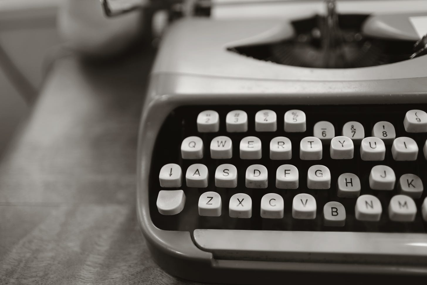 black and white image of a typewriter on a desk
