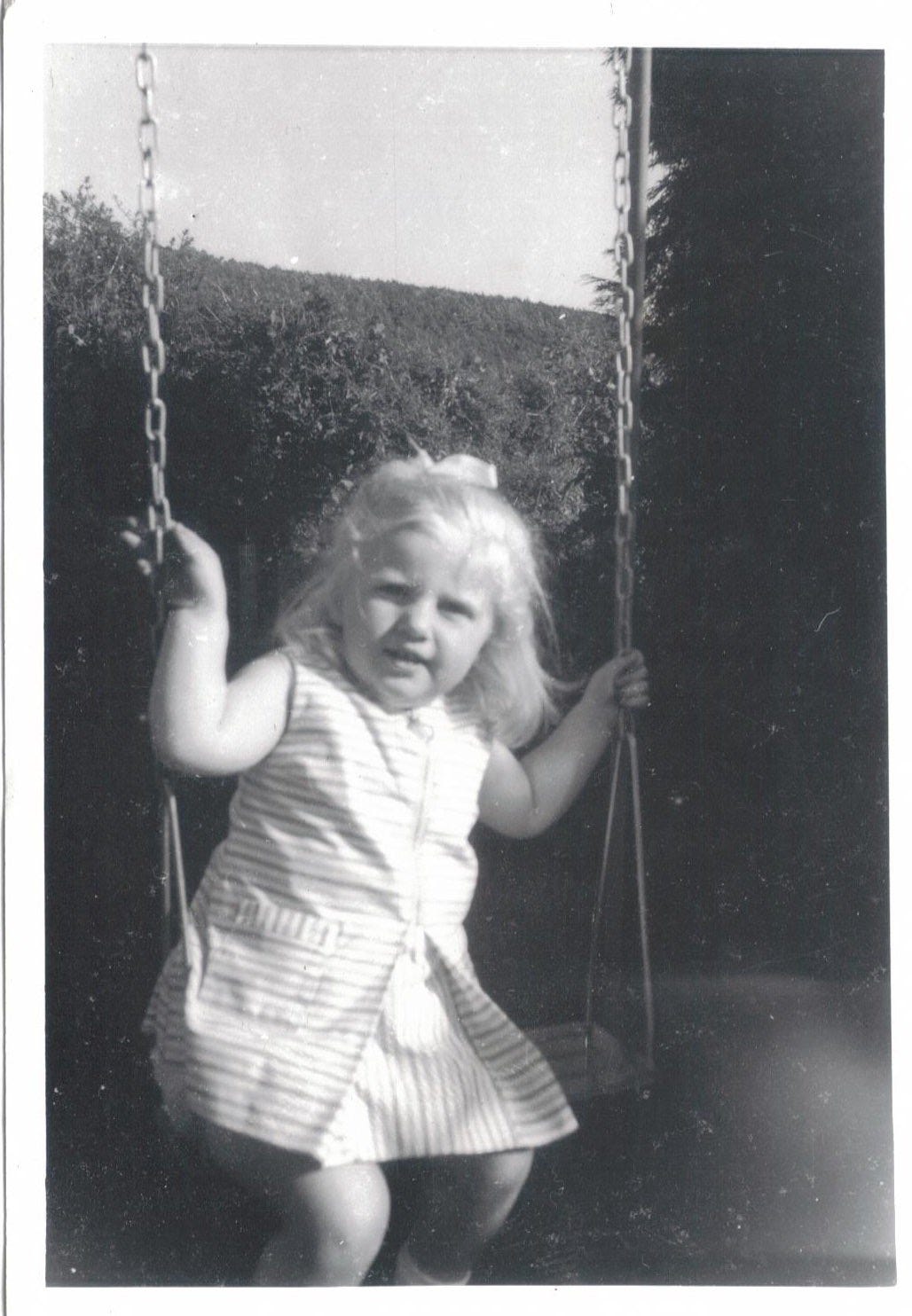 Suzy Starlite age three on a swing in the back garden, Ross on Wye, England