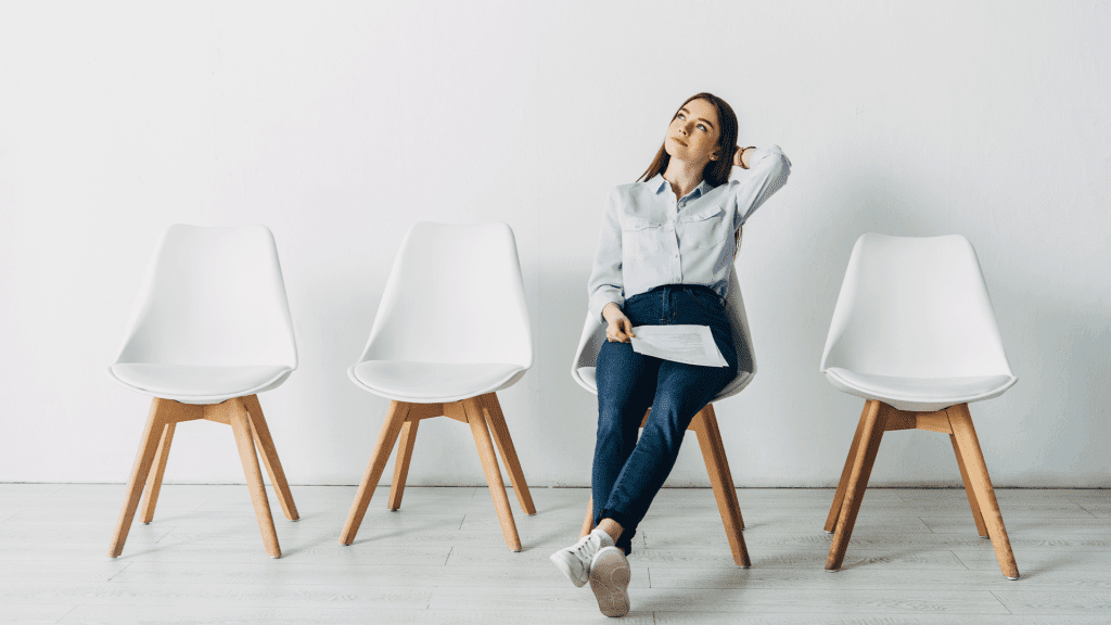 Dreamy applicant with resume sitting on chair in office