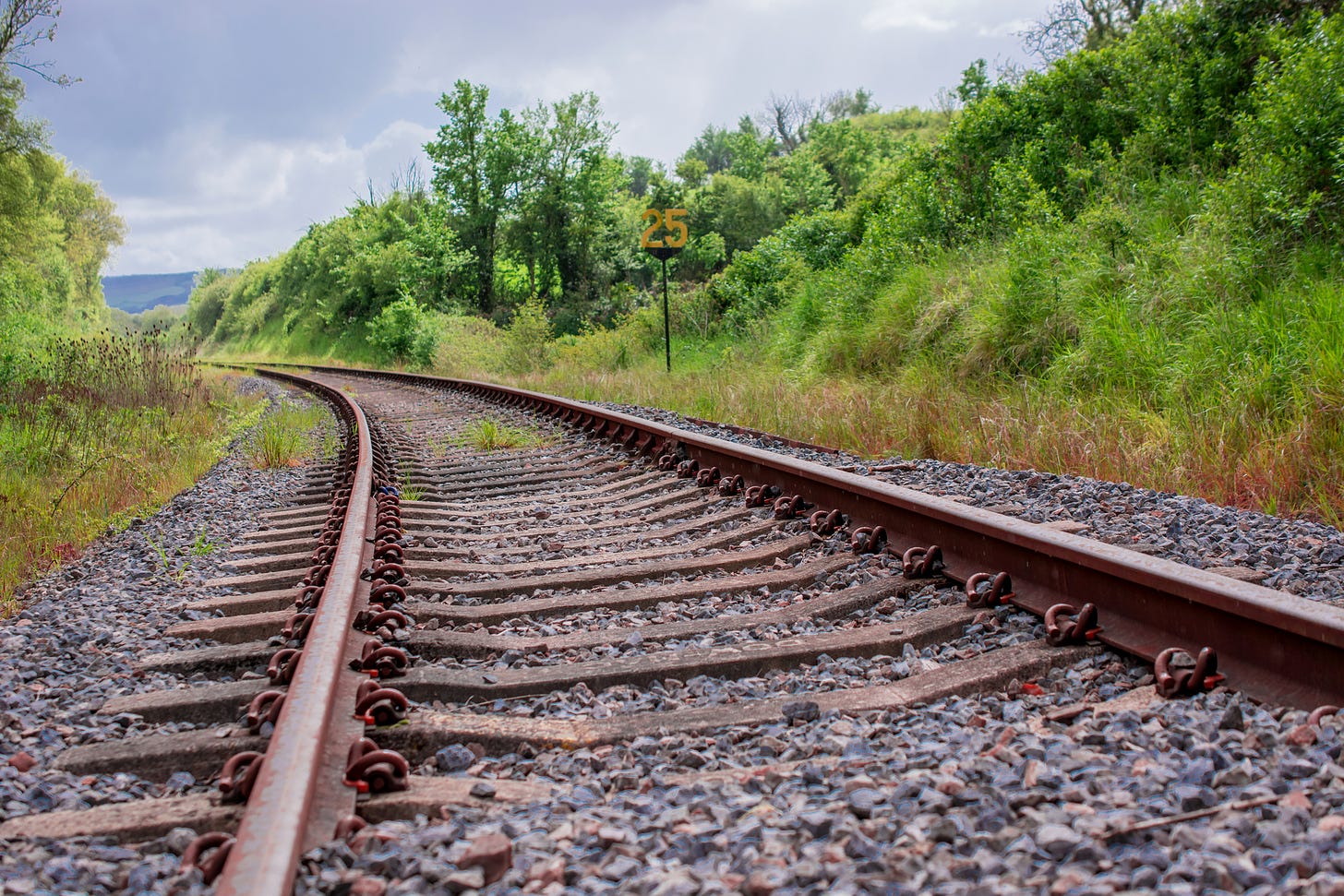 Railway tracks heading into a bend in a rural setting.