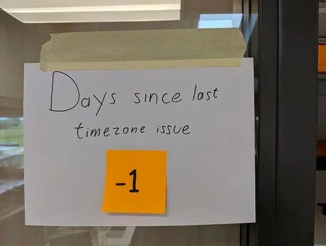 A hand-written sign reading: “DAYS SINCE LAST TIMEZONE ISSUE: -1”