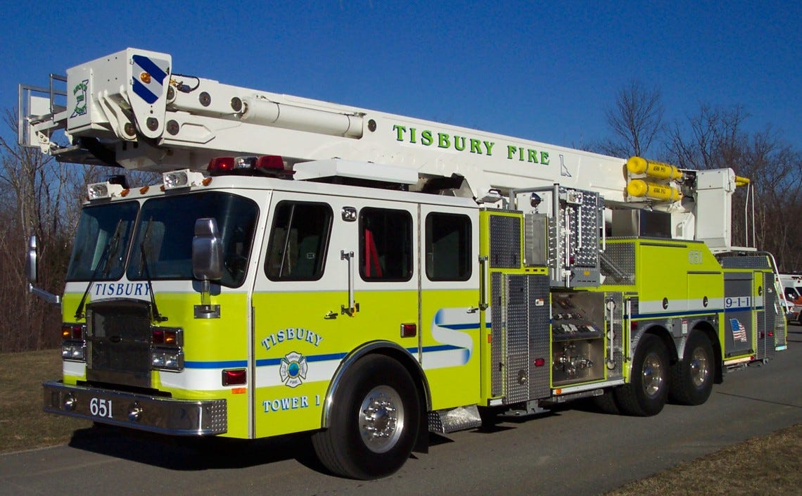 Photgraph of a large fire truck with an extensible 100' long ladder atop it.