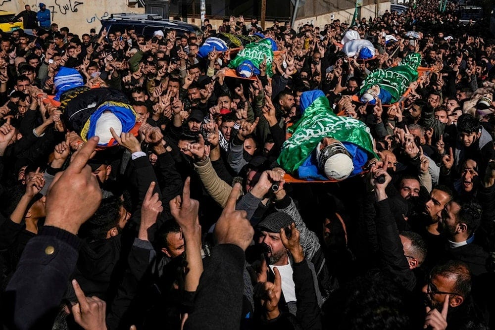 People carry the bodies of Palestinians who were killed in an Israeli airstrike, some draped in the flags of the Palestinian Islamic Jihad and Hamas, during their funeral in the West Bank city of Tammun, Thursday, Jan. 30, 2025 (AP)