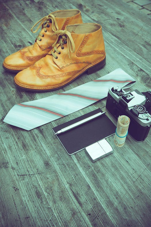 Image of a brown shoe with a tie and other pieces on the floor.