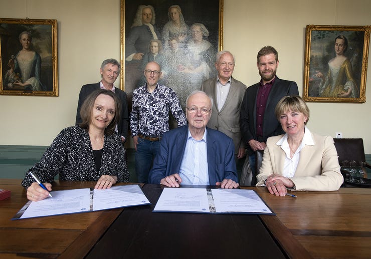 Chris Oomen (midden) tijdens de ondertekening van de overeenkomst, in aanwezigheid van Peter Burger en Alexander Pleijter (beide links achteraan) van Nieuwscheckers.