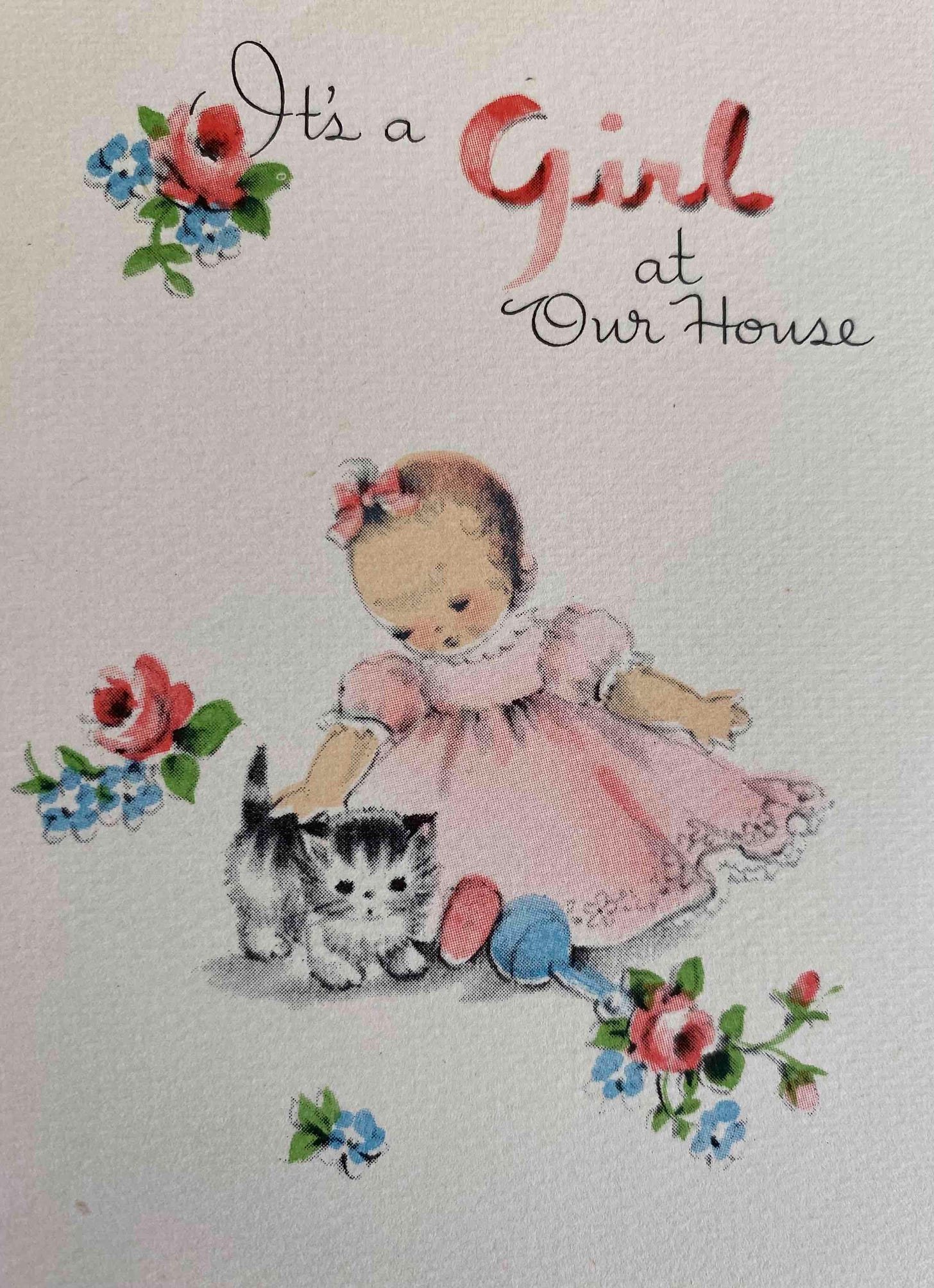 Baby wearing a frilly pink dress and a pink hair bow is petting a tiny gray striped kitten. The caption reads"It's a girl at our house". 