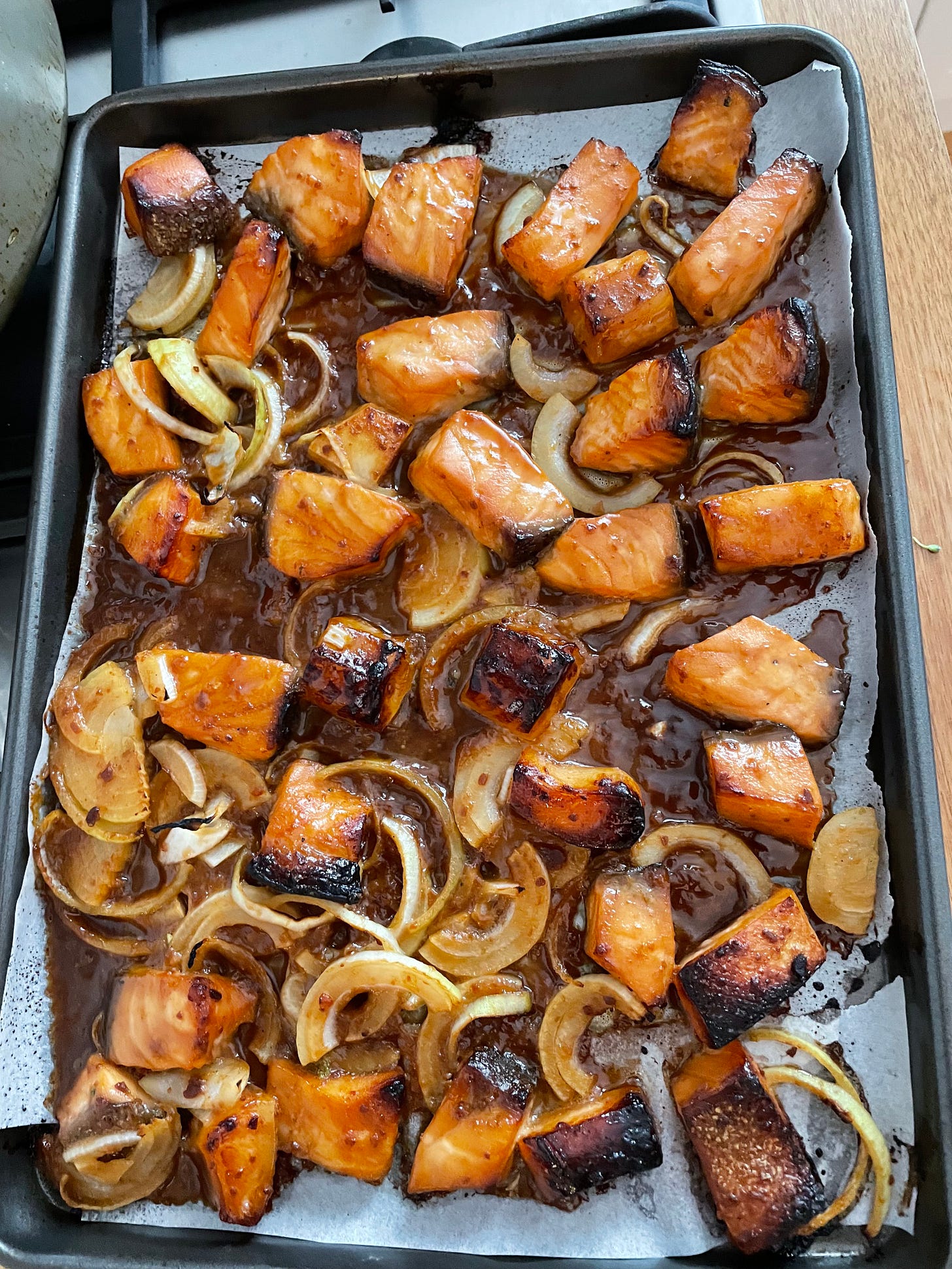 Salmon cubes roasted on a tray with onion and doenjang sauce