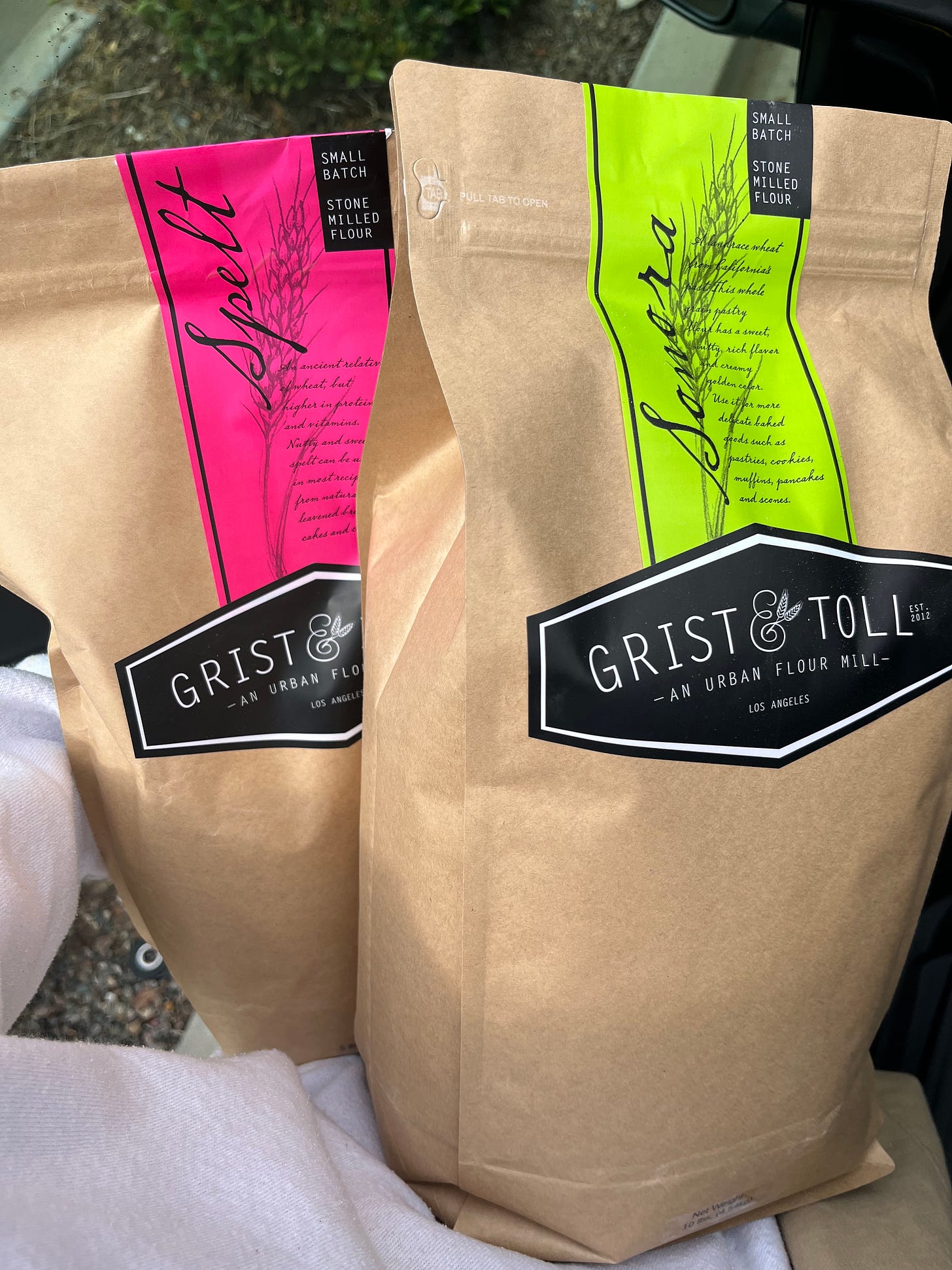Image of two bags of Grist and Toll flour, one Spelt one Sonora.