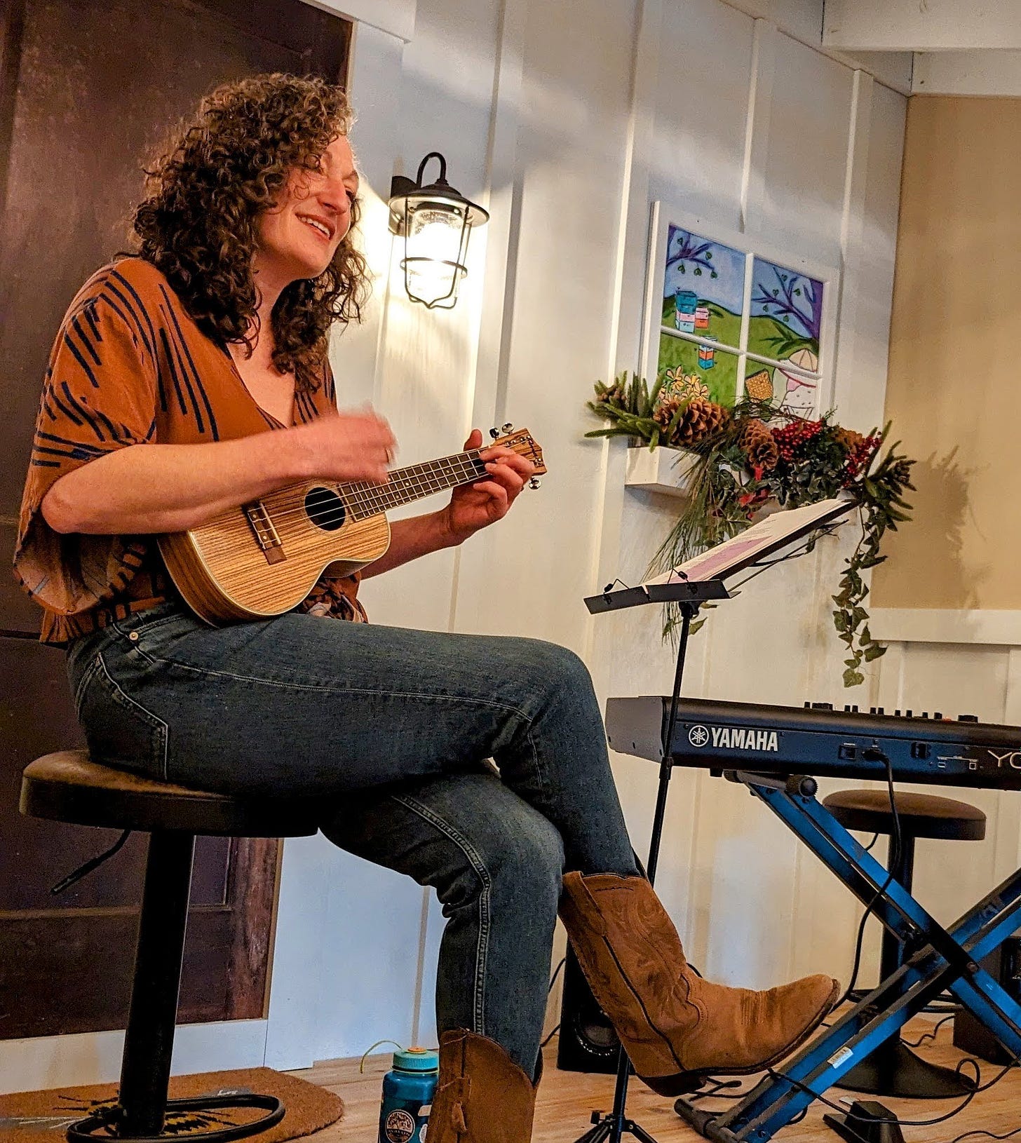 Jenny with ukulele, singing with a smile on her face.