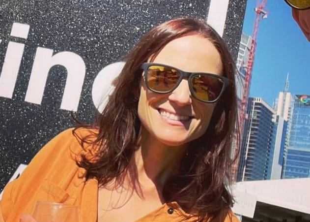 The author smiling in front of some buildings