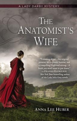 Book cover: The Anatomist's Wife by Anna Lee Huber, depicting a woman in a red cloak look out at a vista including a Georgian manor
