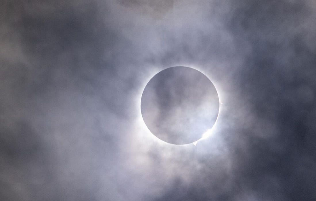 Cloudy, moody photo of solar eclipse at its height over Buffalo, NY