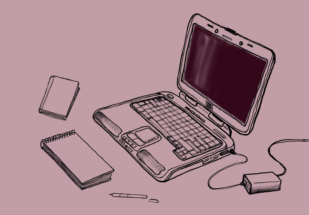 Laptop rodeado de caderno, livro e caneta.
