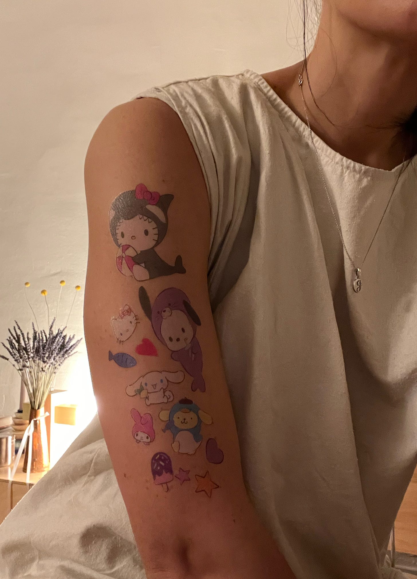 Image of a woman's arm covered in temporary Sanrio tattoos.