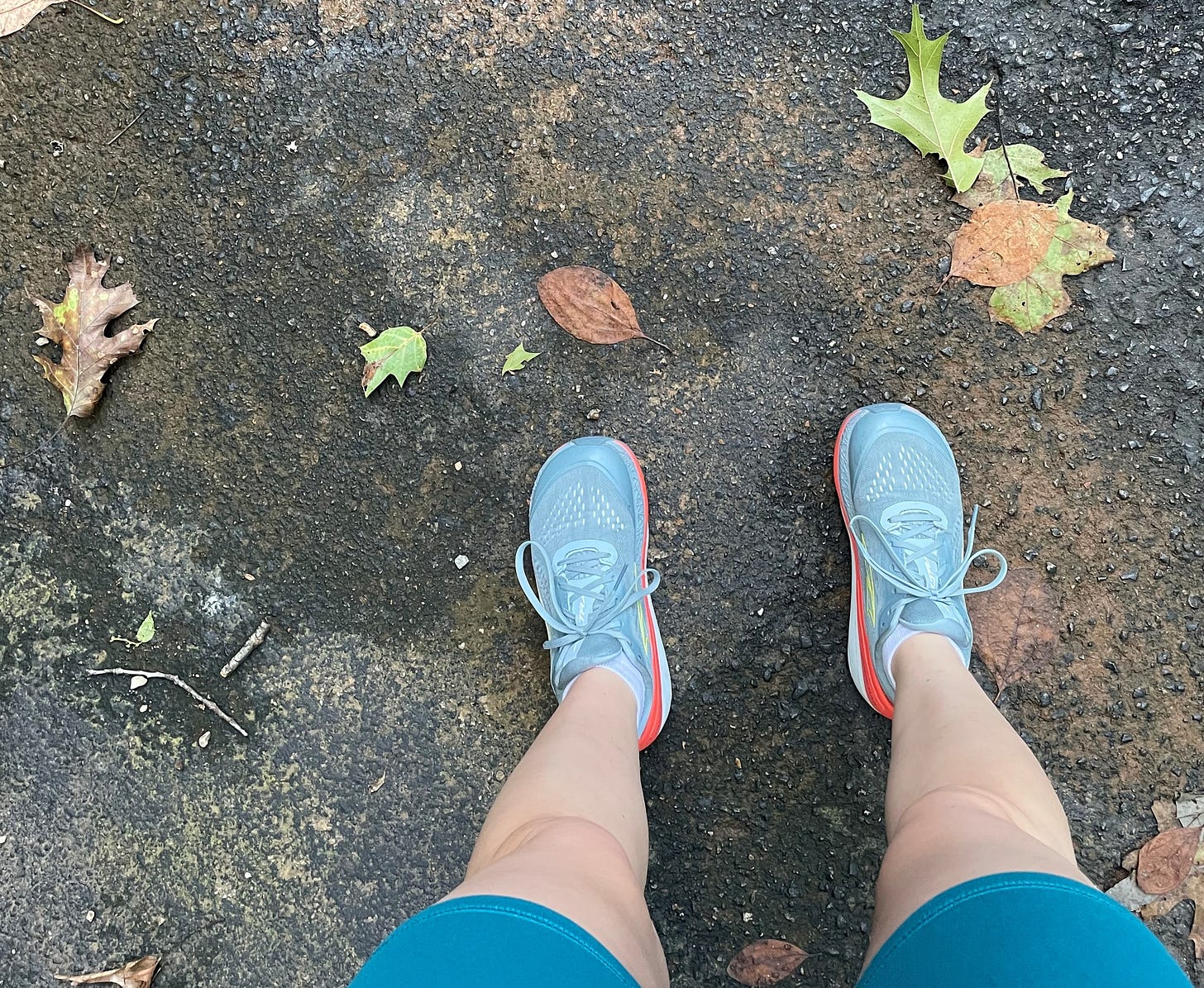 Image looking toward the ground of feet in running shoes