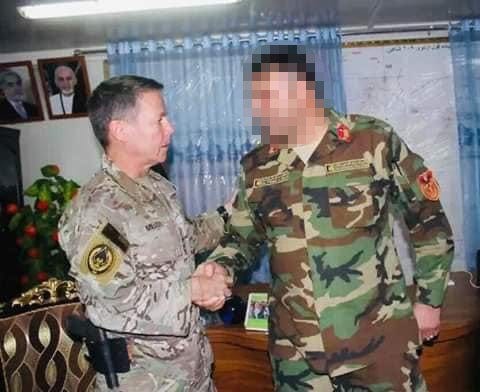 <p>The Afghan colonel shakes hands with four-star US general and then head of Nato forces in Afghanistan, Austin Scott Miller </p>
