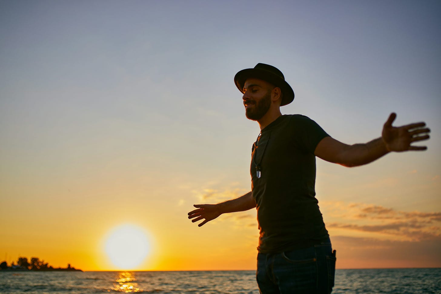 特色图片：a man standing on top of a beach next to the ocean