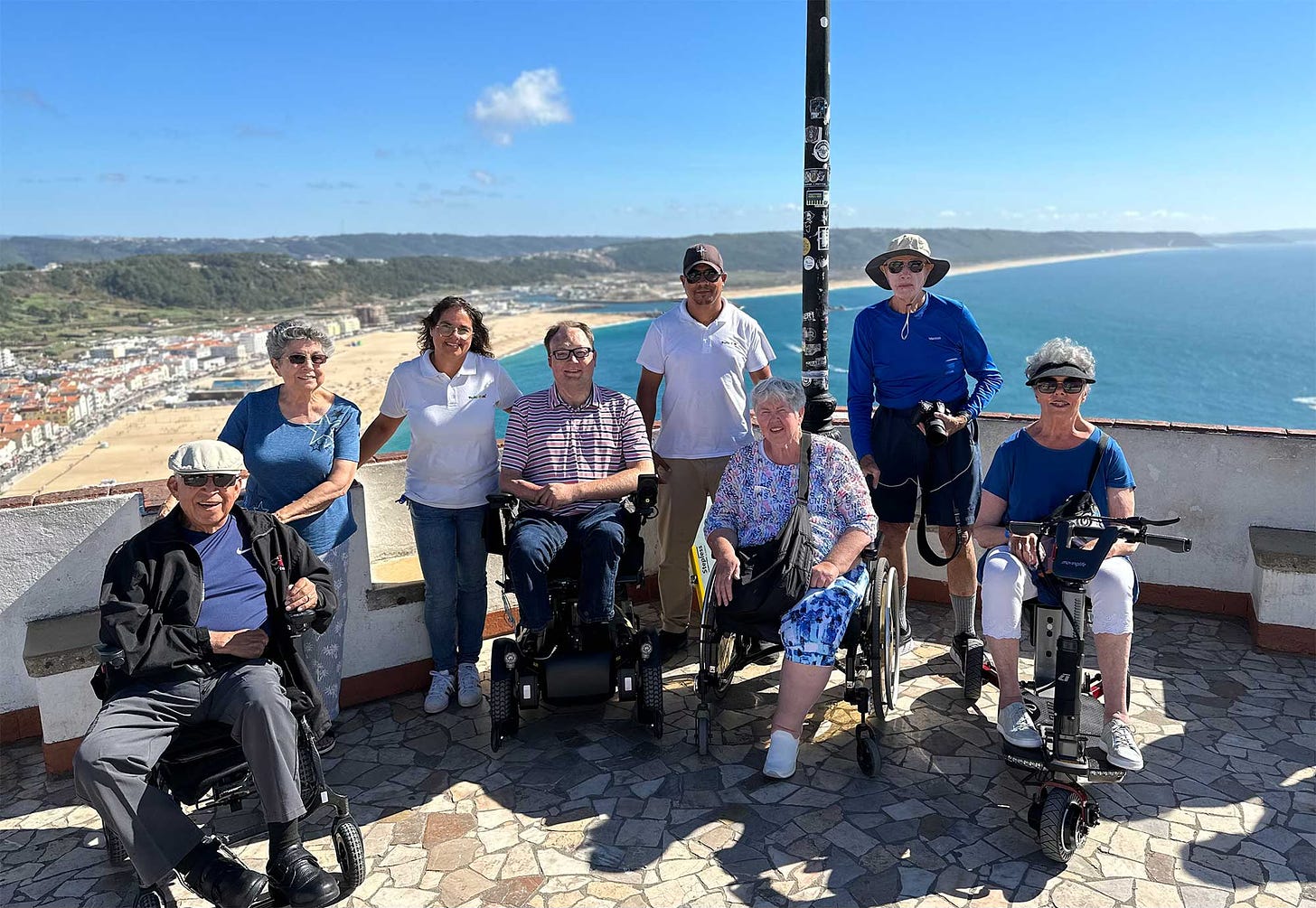 John with a group of travelers overlooking a Portuguese beach town.