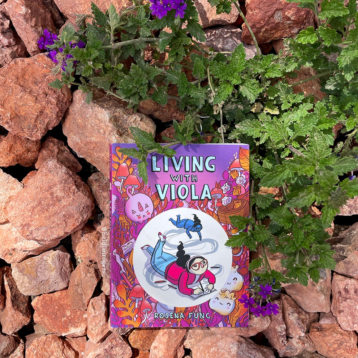Cover of Living With Viola by Rosena Fung on orange rocks with purple flowers