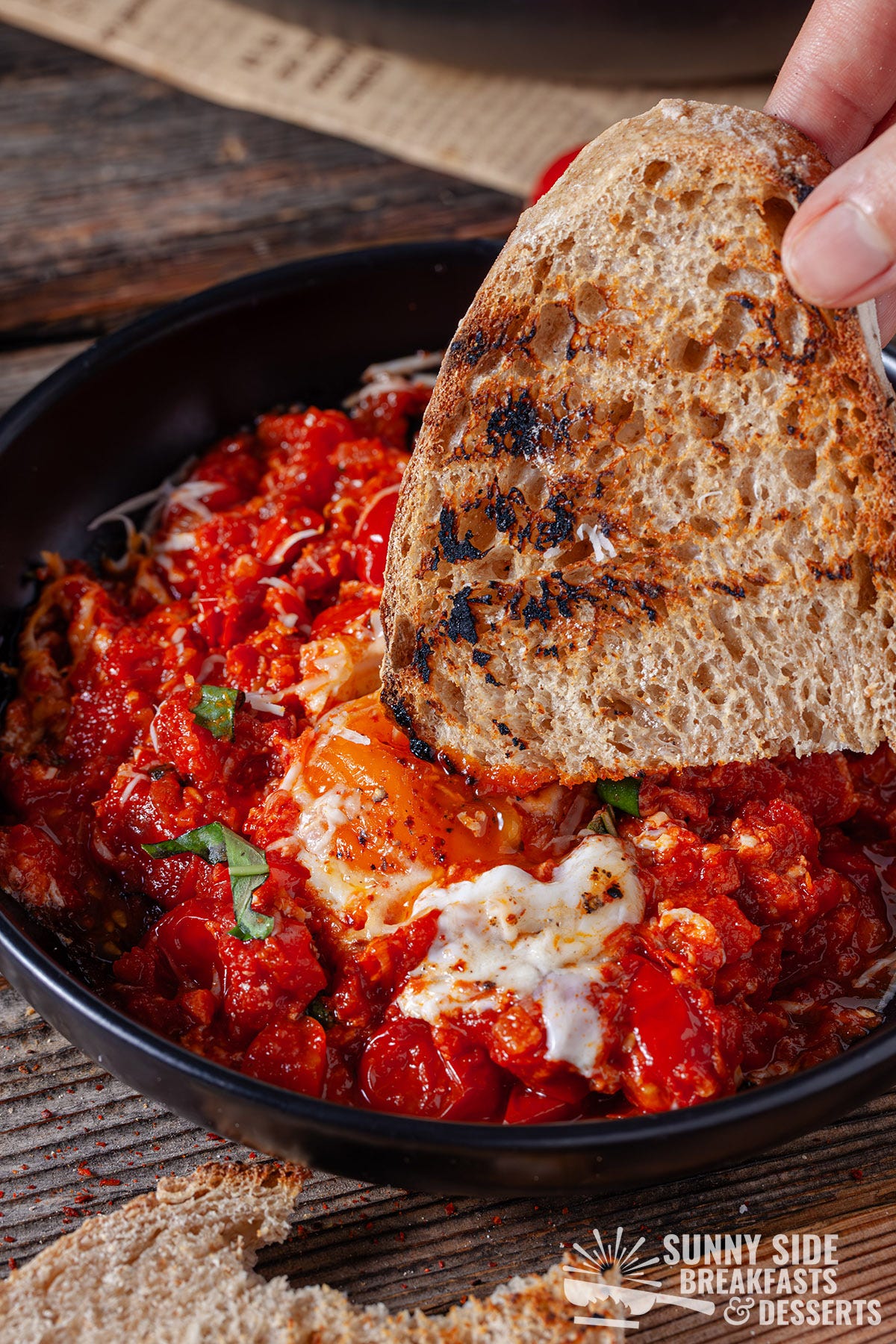 Dipping toasted sourdough bread into eggs purgatory.