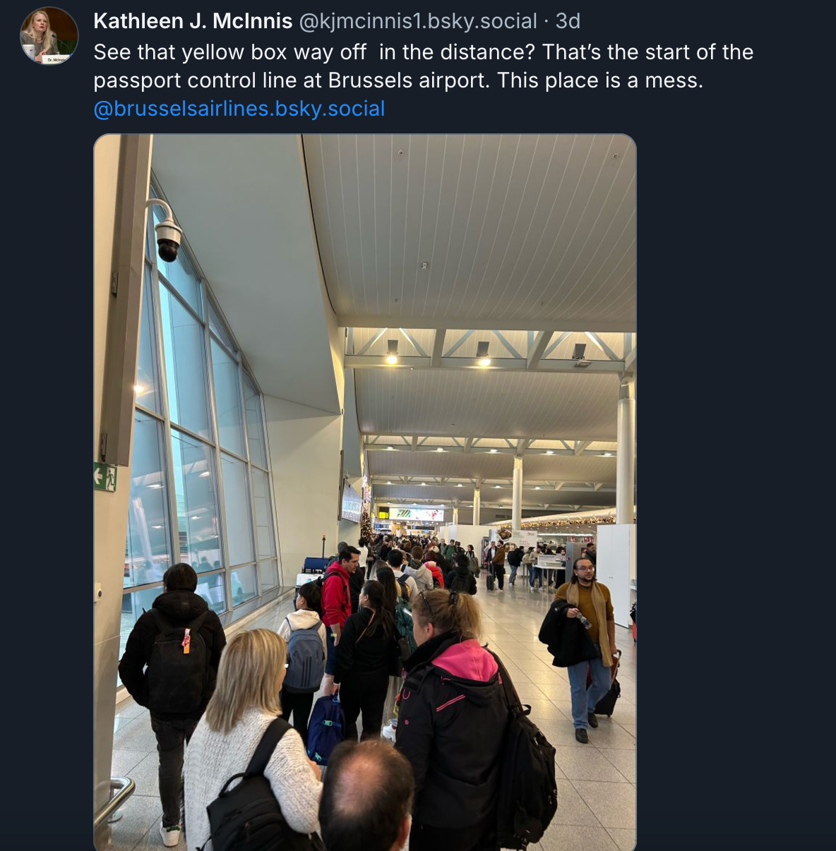 A photo of a long, long line. "See that yellow box way off  in the distance? That’s the start of the passport control line at Brussels airport. This place is a mess.  @brusselsairlines.bsky.social"