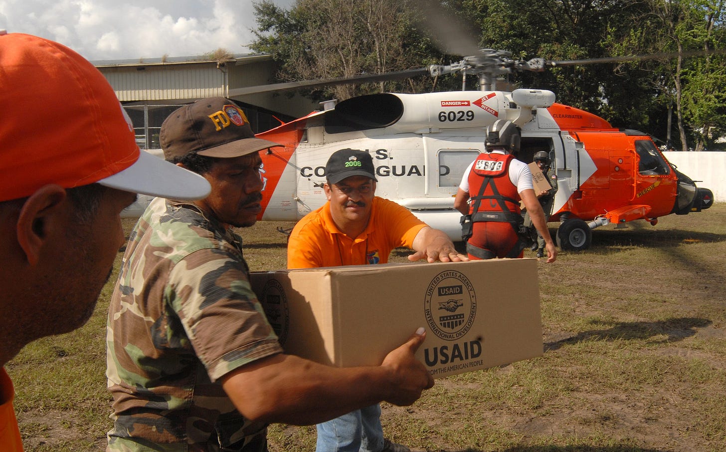 US coast guard personnel loading USAID packages onto a helicopter