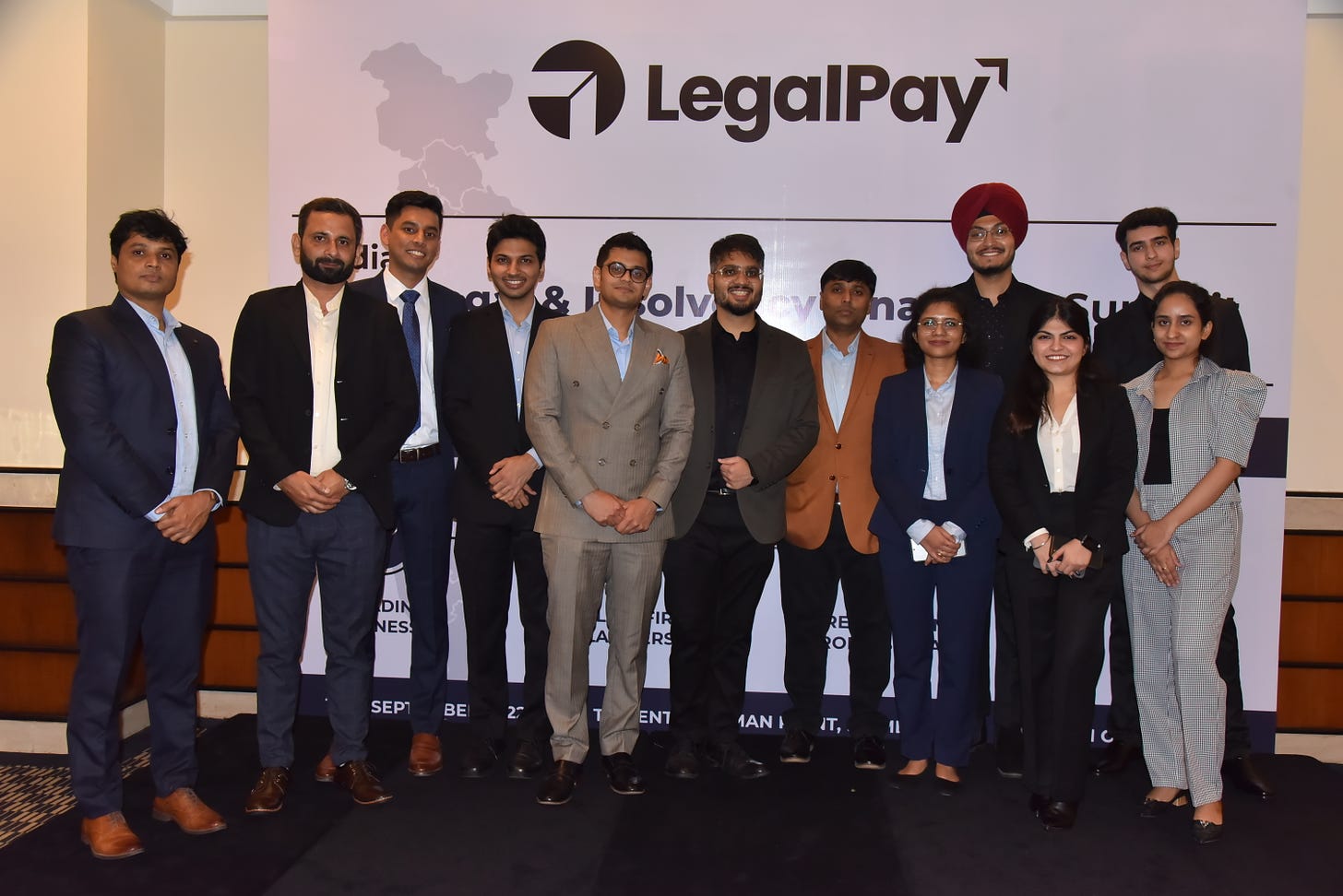 A group of people, consisting of the team of LegalPay, standing under a banner displaying their organisation's name