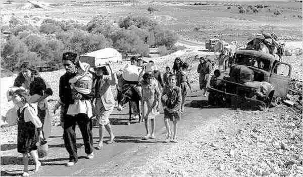 A group of Palestinian refugees carry their possessions on foot