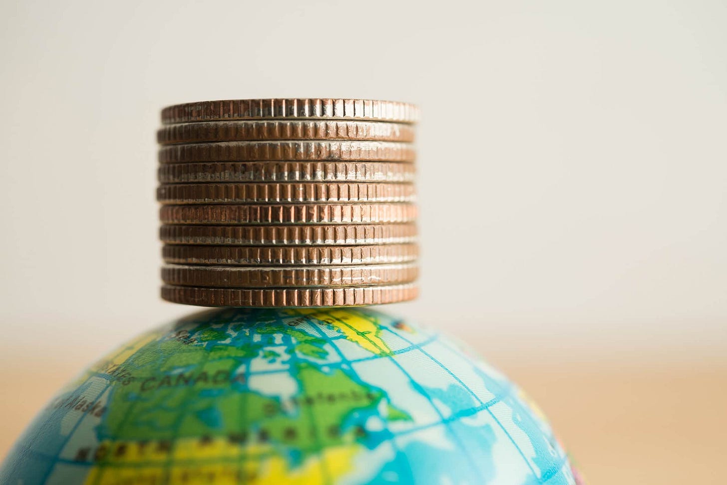 Close up stack coins on world globe with white background copy space.