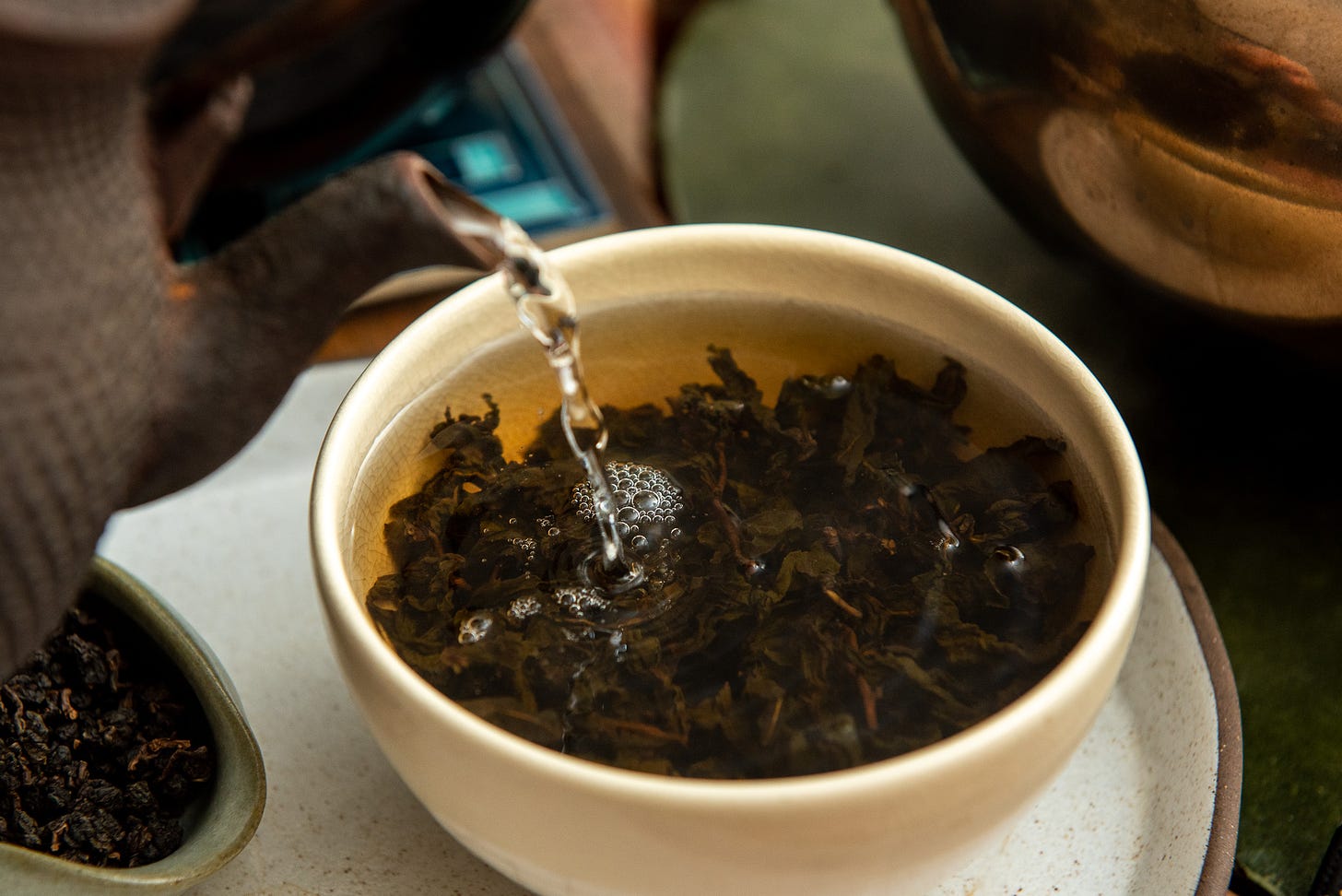 ID: Tetsubin pouring water into a bowl with oolong tea leaves