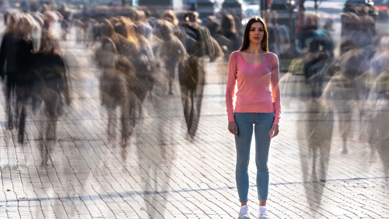 woman standing alone in busy crowd