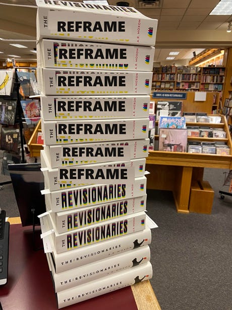 Photo of a stack of copies of The Revisionaries in a bookstore. The title on the spine has been clumsily altered to read "The Reframe"