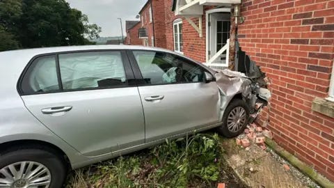 Derbyshire Fire and Rescue Service The car was left embedded in the front of the house