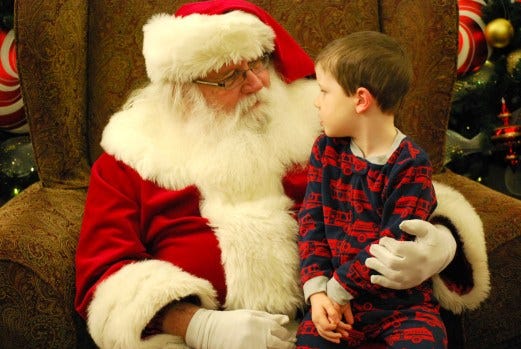Jim Hines, who played Santa Claus in the Williamsburg area, died March 30 at age 72. Here is pictured in 2016 at Yankee Candle wuth then-3-year-old Cooper Sutton-Melson of Newport News. Virginia Gazette file