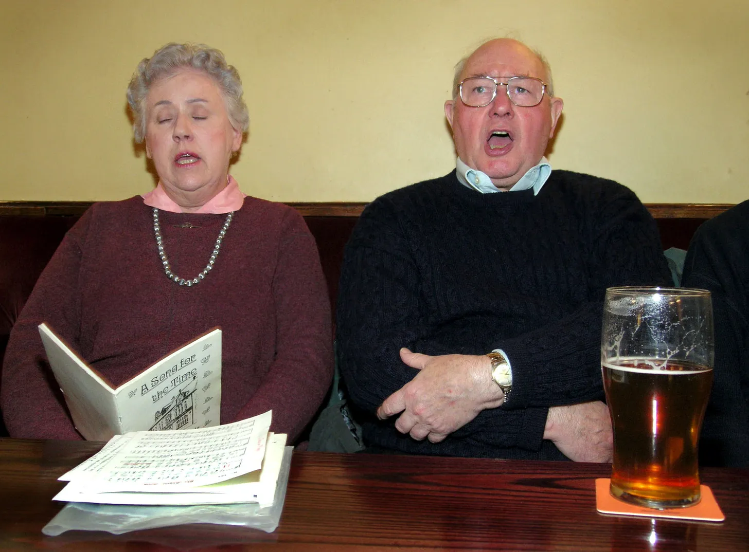 A woman and a man carol singing at the Black Bull in Ecclesfield in 2005
