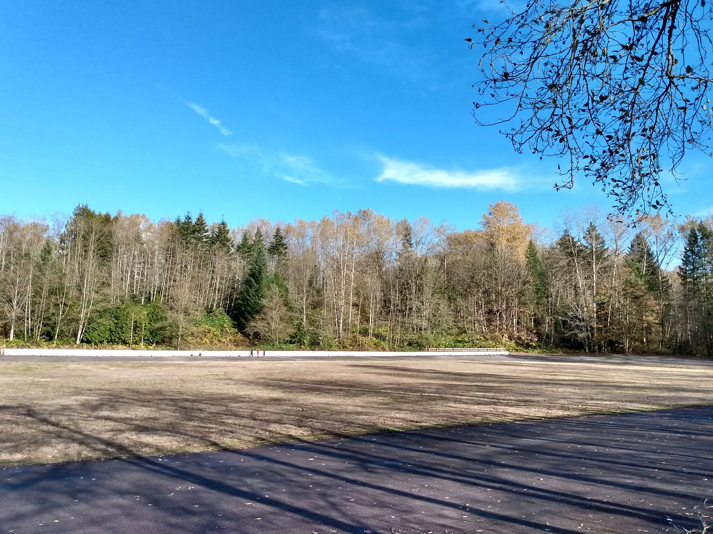 Fotografía de la Langley Speedway, hay un claro cielo azul, unos árboles y la pista está pavimentada
