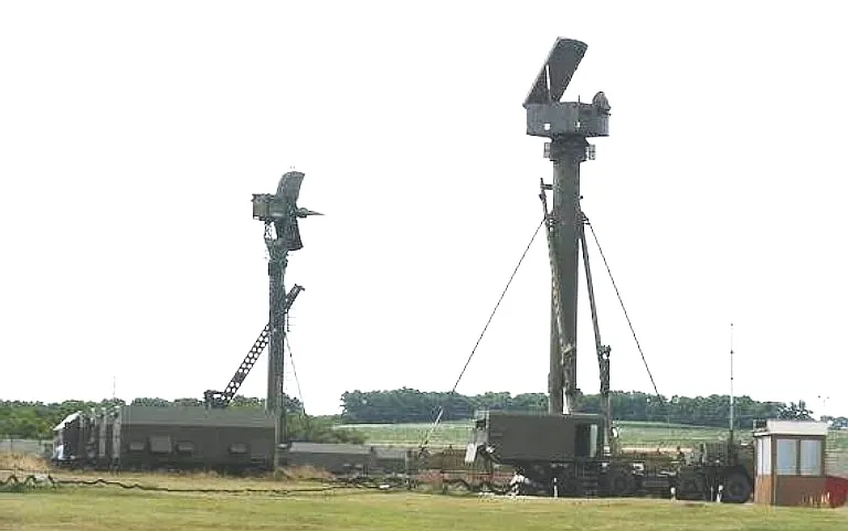 A deployed S-300PS / SA-10B battery showing the 5N63S Flap Lid B and 5N66 Clam Shell A deployed on 40V6M 24 metre masts. Note the MAZ-7910 radar vehicle with the antenna head removed.