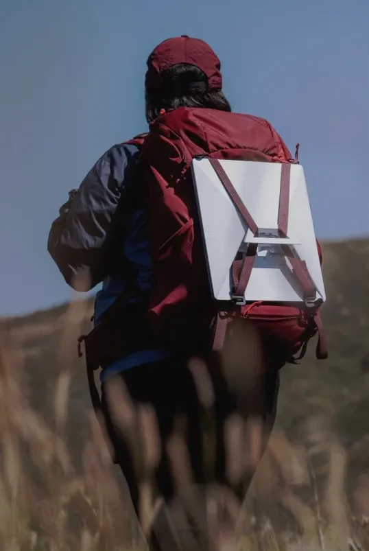 Image of a hiker with a StarLink Mini strapped to the outside of their backpack