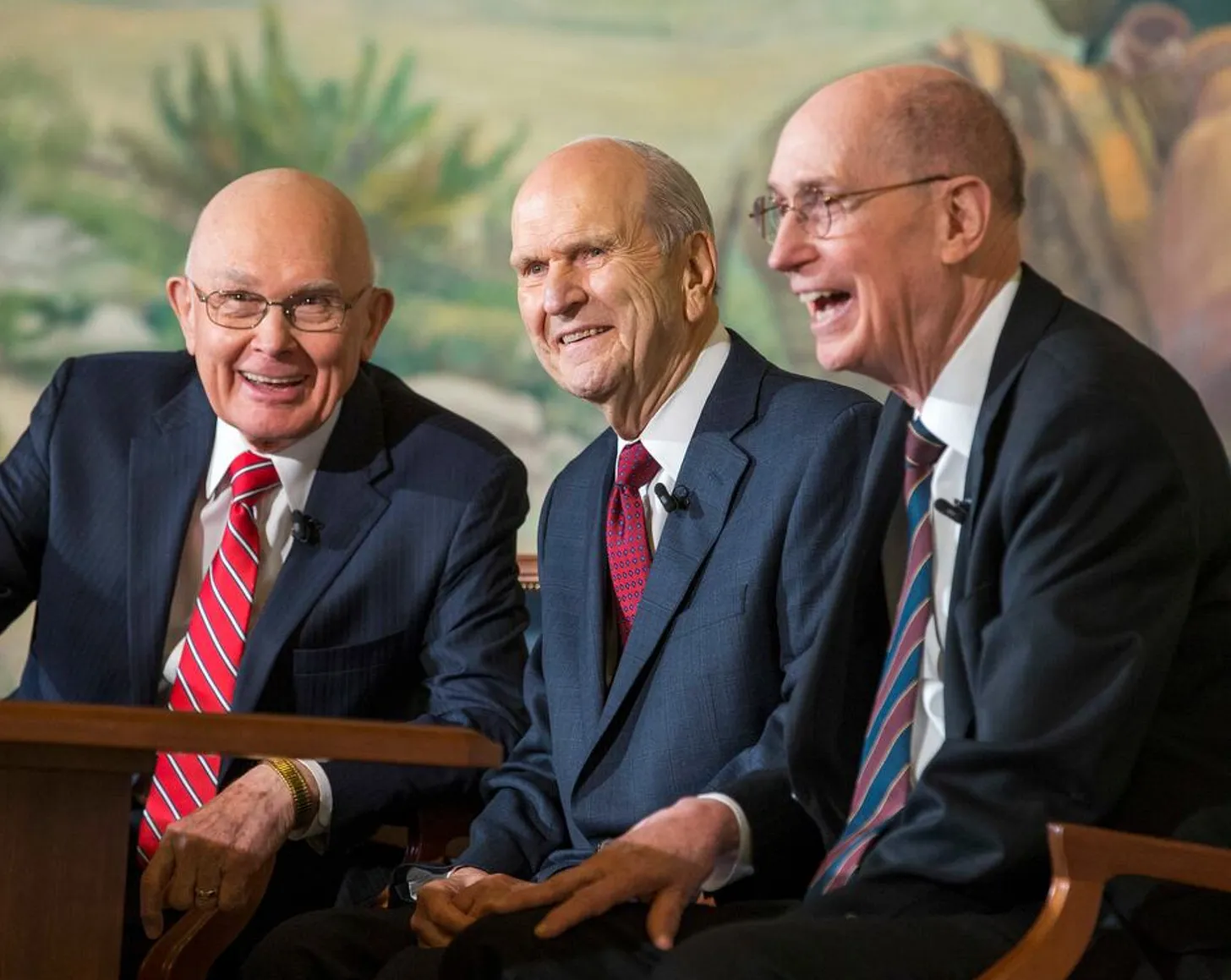 President Russell M. Nelson, flanked by his counselors President Dallin H. Oaks and President Henry B. Eyring, sit smiling during a press conference in Salt Lake City. As senior leaders of The Church of Jesus Christ of Latter-day Saints, they represent a trusted source of light and truth in an age of misinformation, as highlighted in the article’s theme on choosing whom to trust.